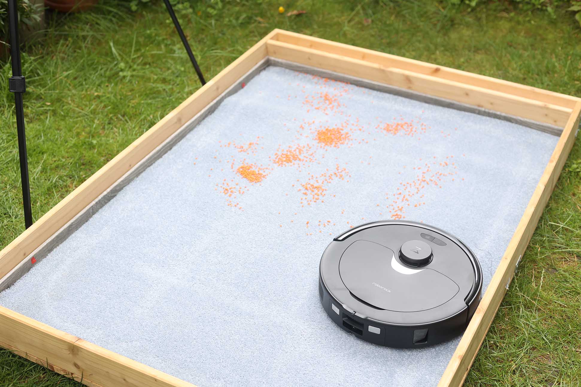 Roborock Q Revo beim Linsen-Saugtest auf einem hohen Teppich.